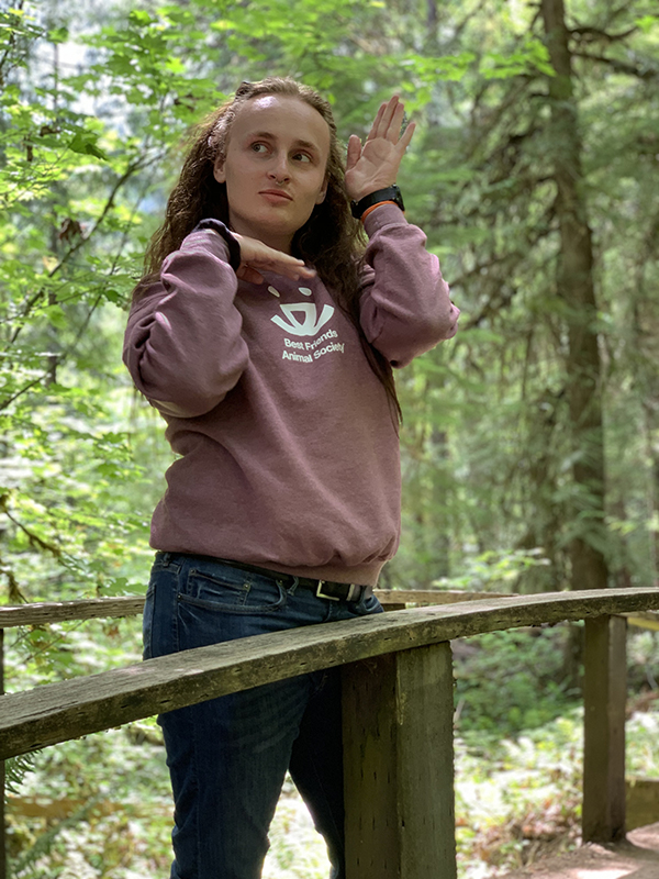 Promose Scholar Drew Reynolds stands on a bridge over a stream